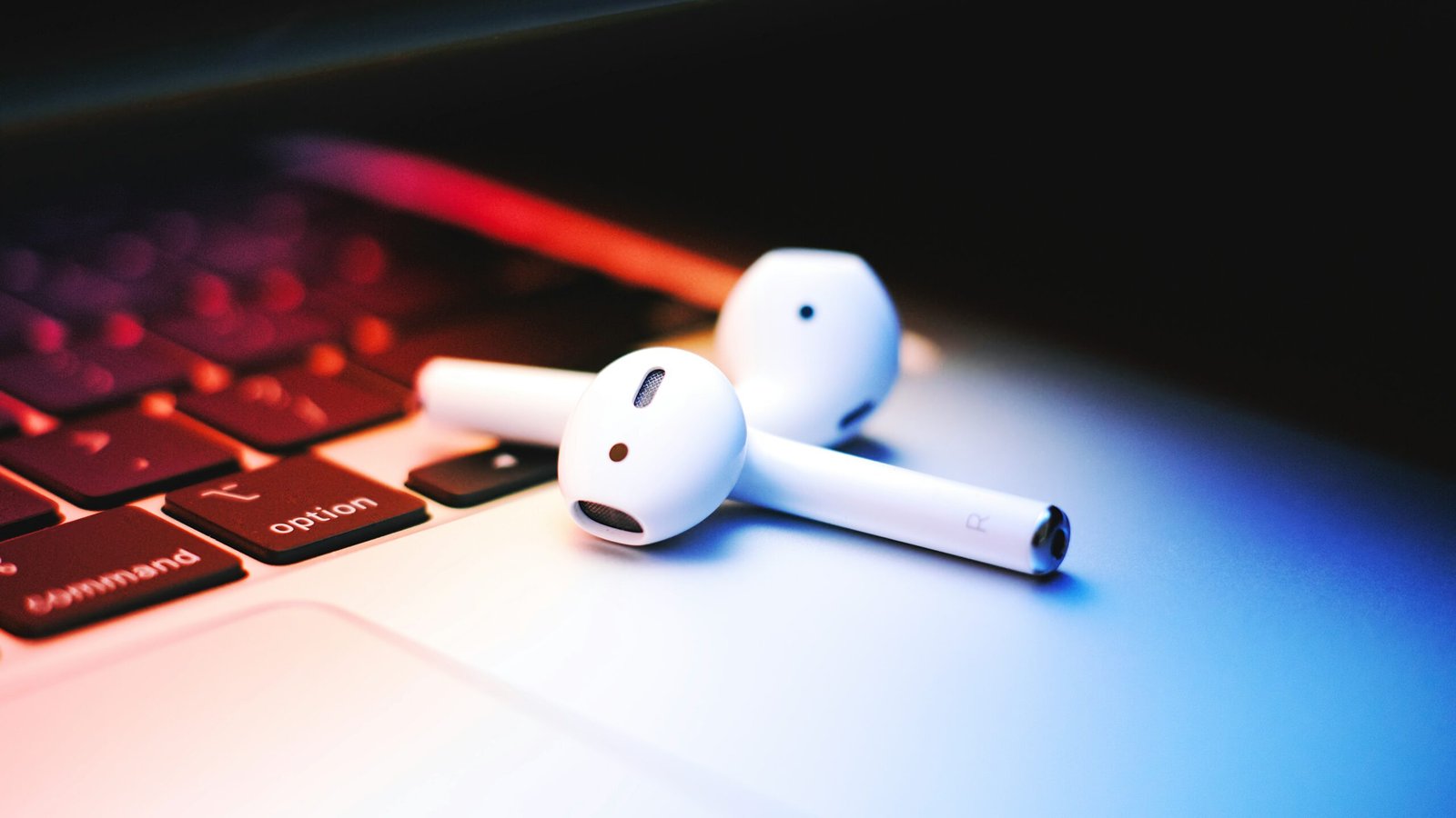 a pair of ear buds sitting on top of a laptop keyboard